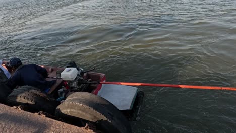 two men docking a small boat by the river