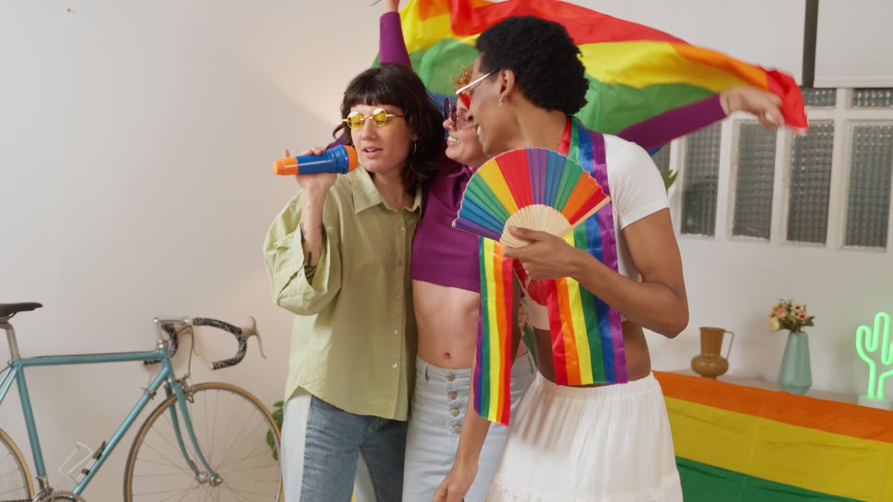 Friends celebrating LGBTQ Pride with rainbow flag and singing
