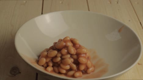 baked beans in tomato sauce pouring into a bowl