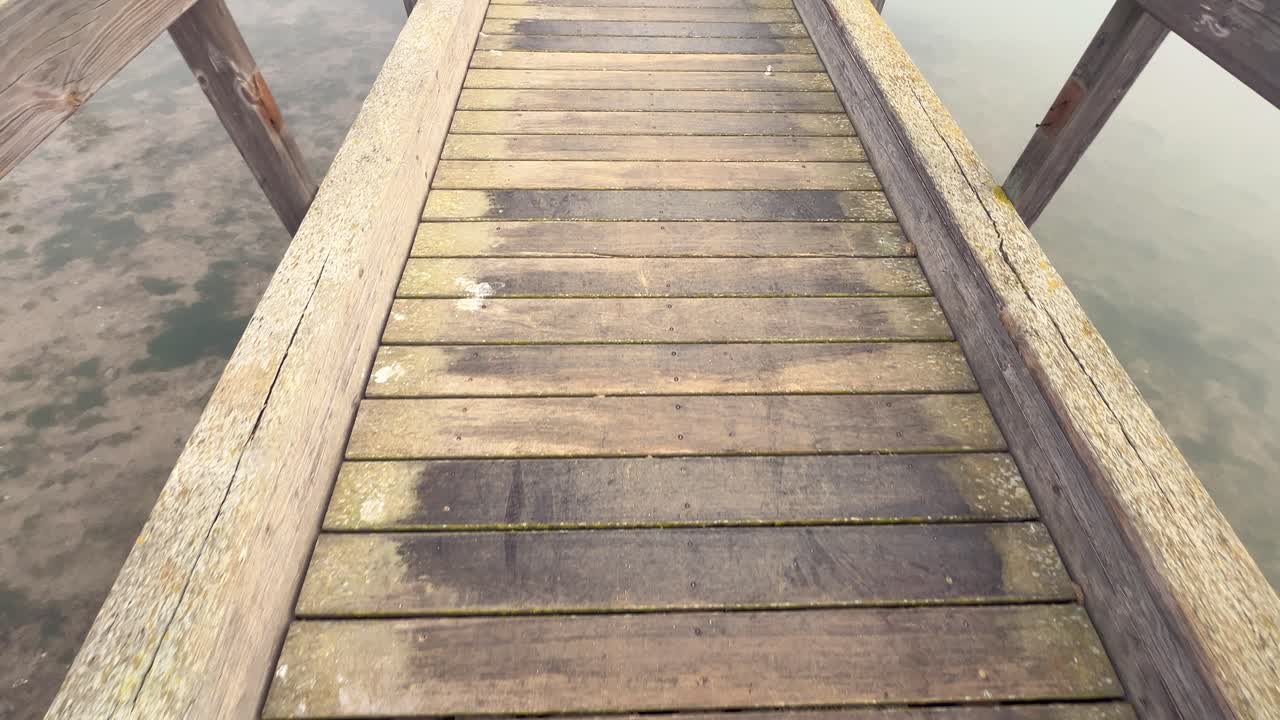 At gå langs vandpromenaden, på en træpromenade, fremkalder en ånd af udforskning og eventyr midt i vandrige omgivelser.