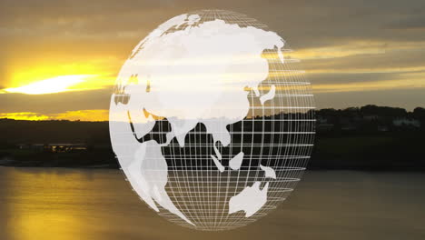 animación de globo giratorio sobre el paisaje del atardecer con agua y colinas distantes