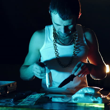 drug dealer takes a package with a drug and cuts it with a knife to sample it. abuse of drugs. criminal business square video