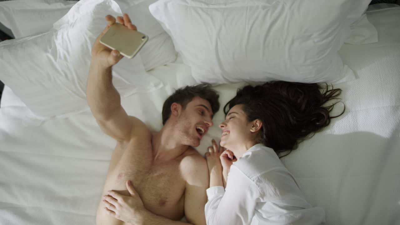 una pareja sexy acostada en una cama en una habitación de hotel de lujo.