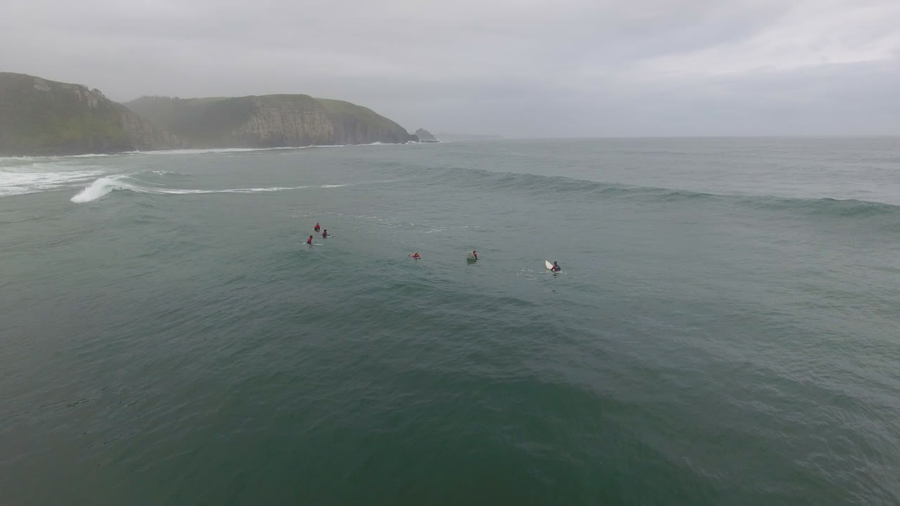 Flygande actionfilmning över surfare som surfar vid Coffee Bay i Sydafrika