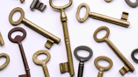 Old keys rotating over white background