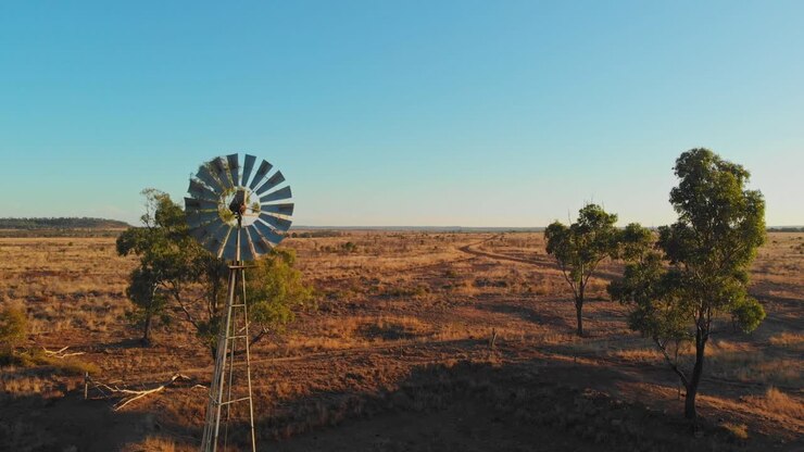 Moinho de vento ao anoitecer no interior de Emerald, Queensland, Austrália