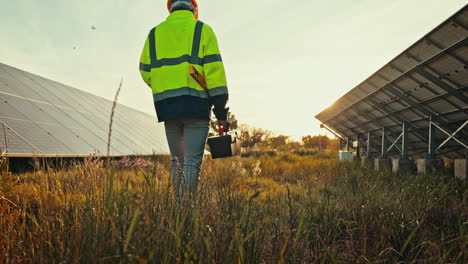 Man-at-solar-panel-farm-with-tools