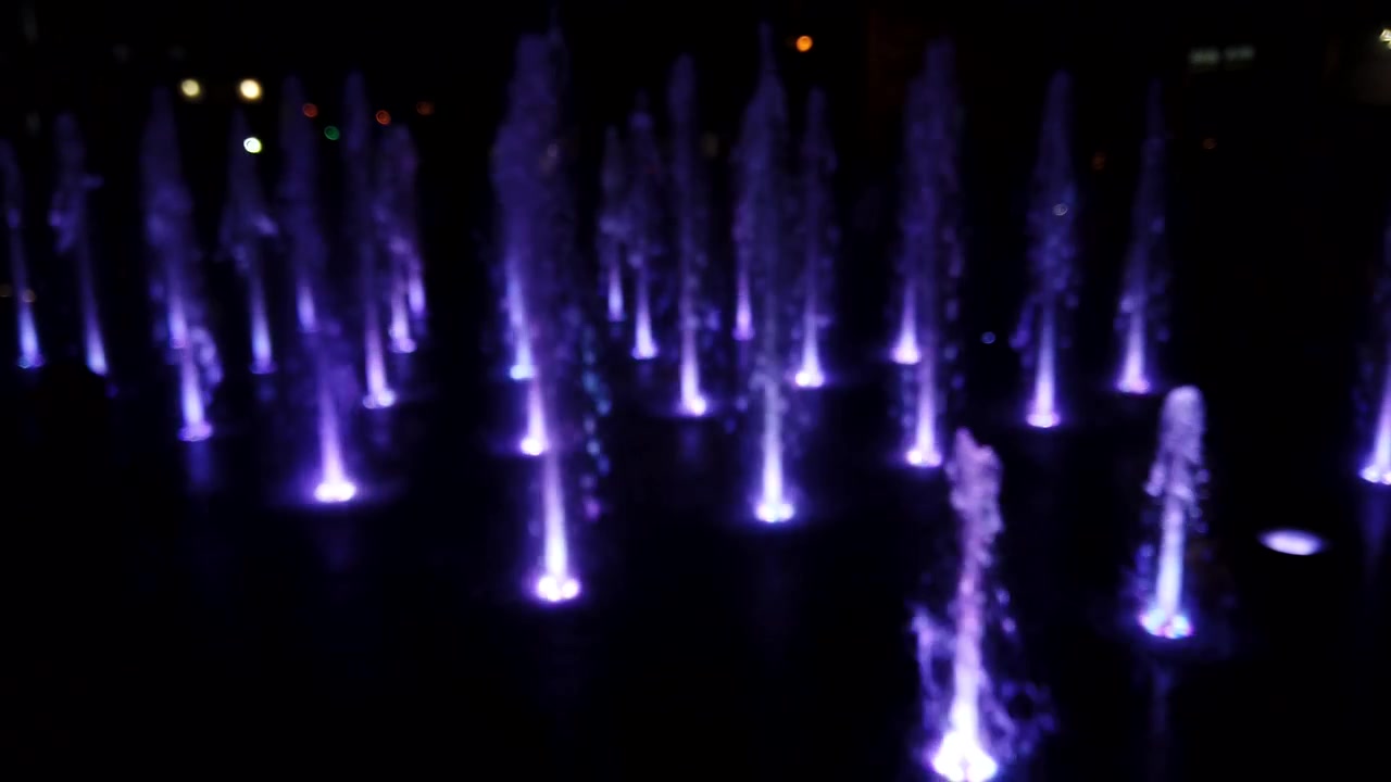 Fountain jets on the city boulevard. Out of focus.