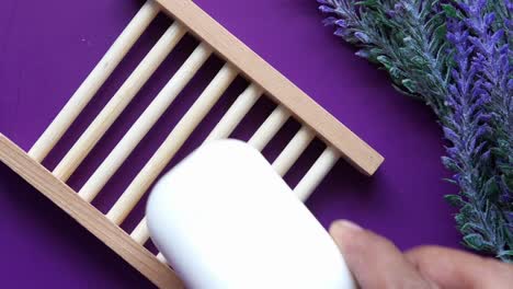 jabón blanco en un plato de jabón de madera con lavanda