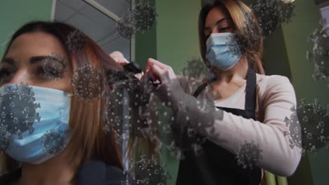 animation of coronavirus cells over caucasian female hairdresser and woman wearing face masks