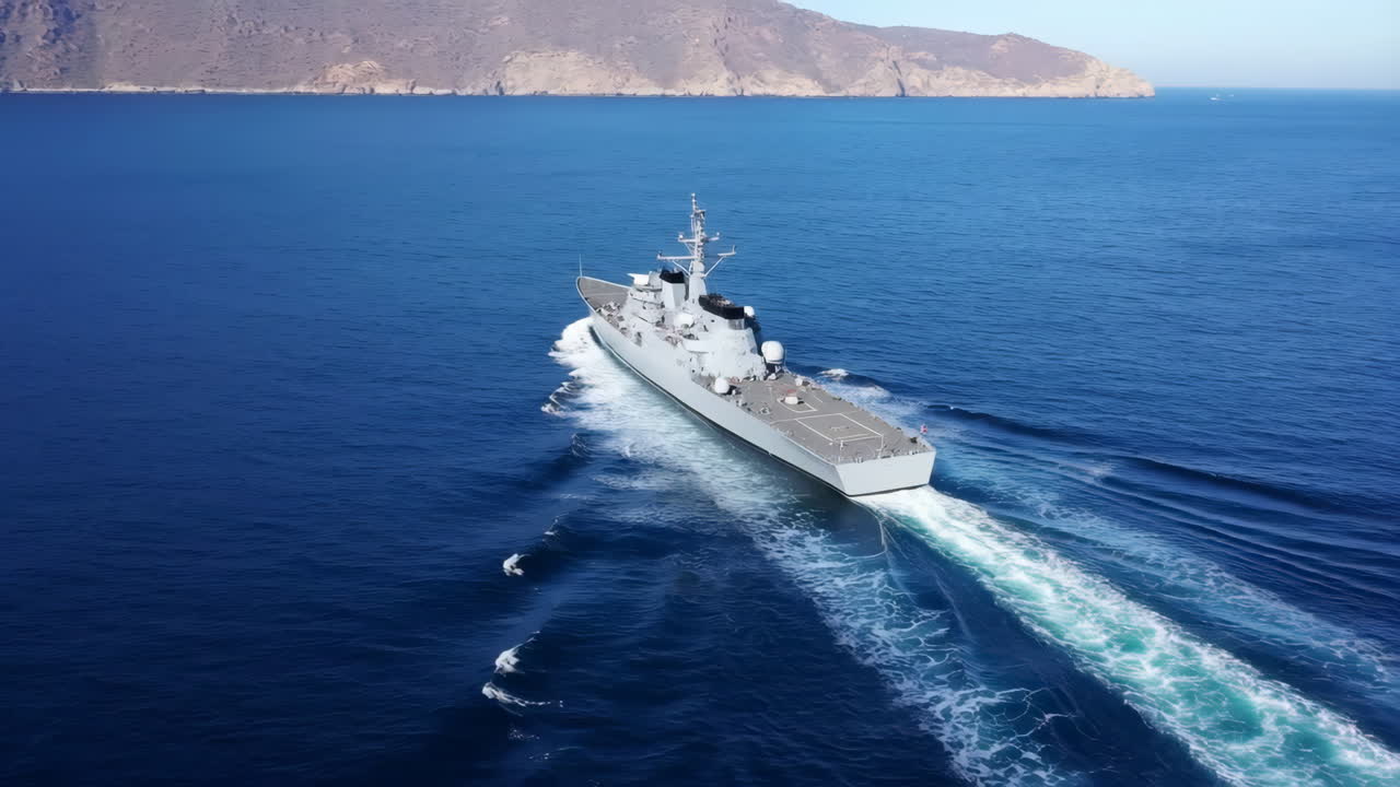 Vista aerea di una nave da guerra che naviga nell'oceano aperto vicino a una costa.