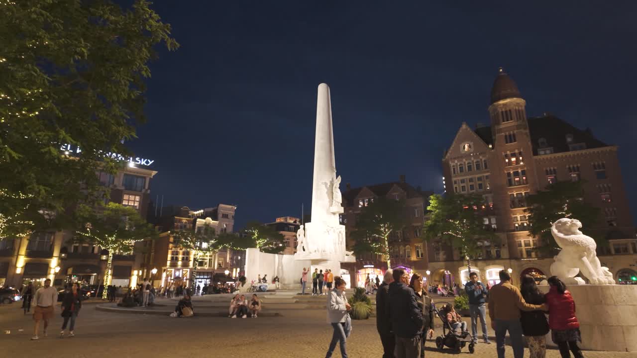 Dam Square at night in Amsterdam, Netherlands, with the National Monument illuminated