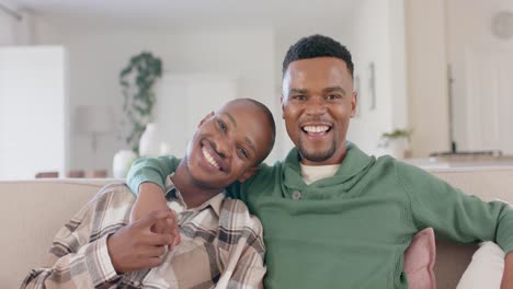 Portrait-of-happy-african-american-gay-male-couple-sitting-on-sofa-and-embracing,-slow-motion