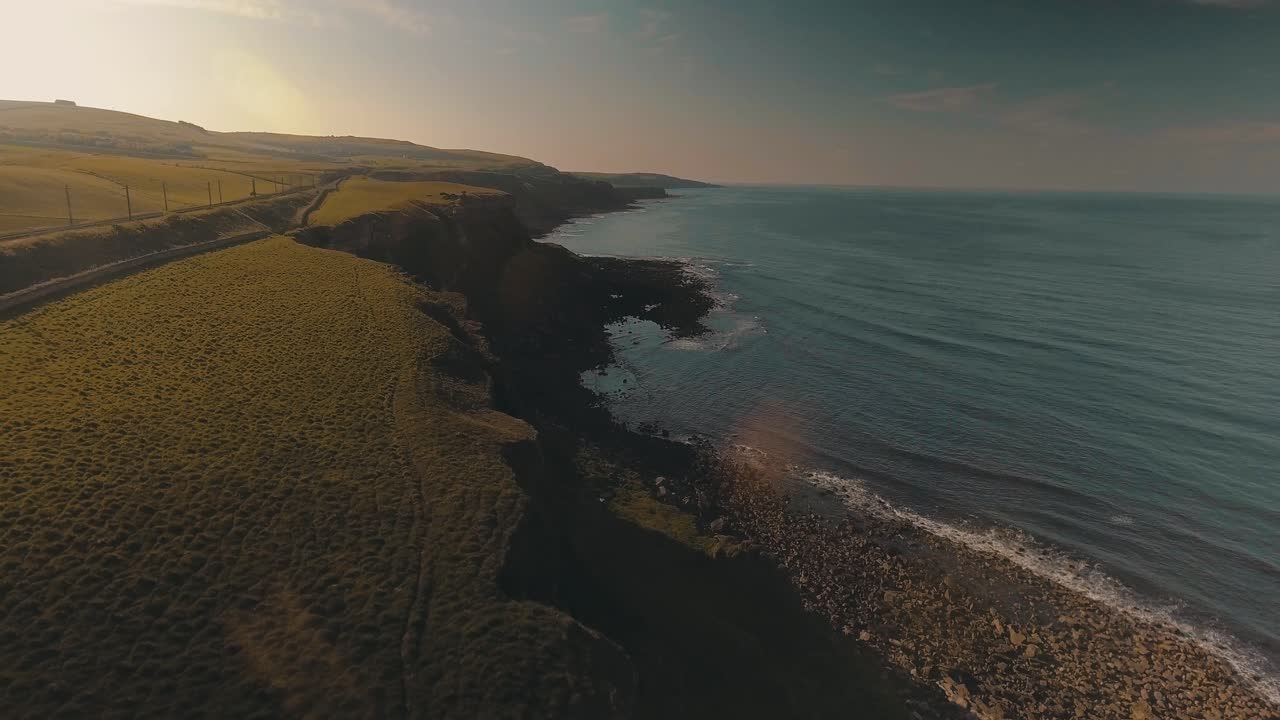 Berwick-Upon-Tweed In Scotland - Drone Capturing A Coastal Cliff With Green Landscape Surrounded By Tranquil Waters At Sunset - Aerial Drone Shot