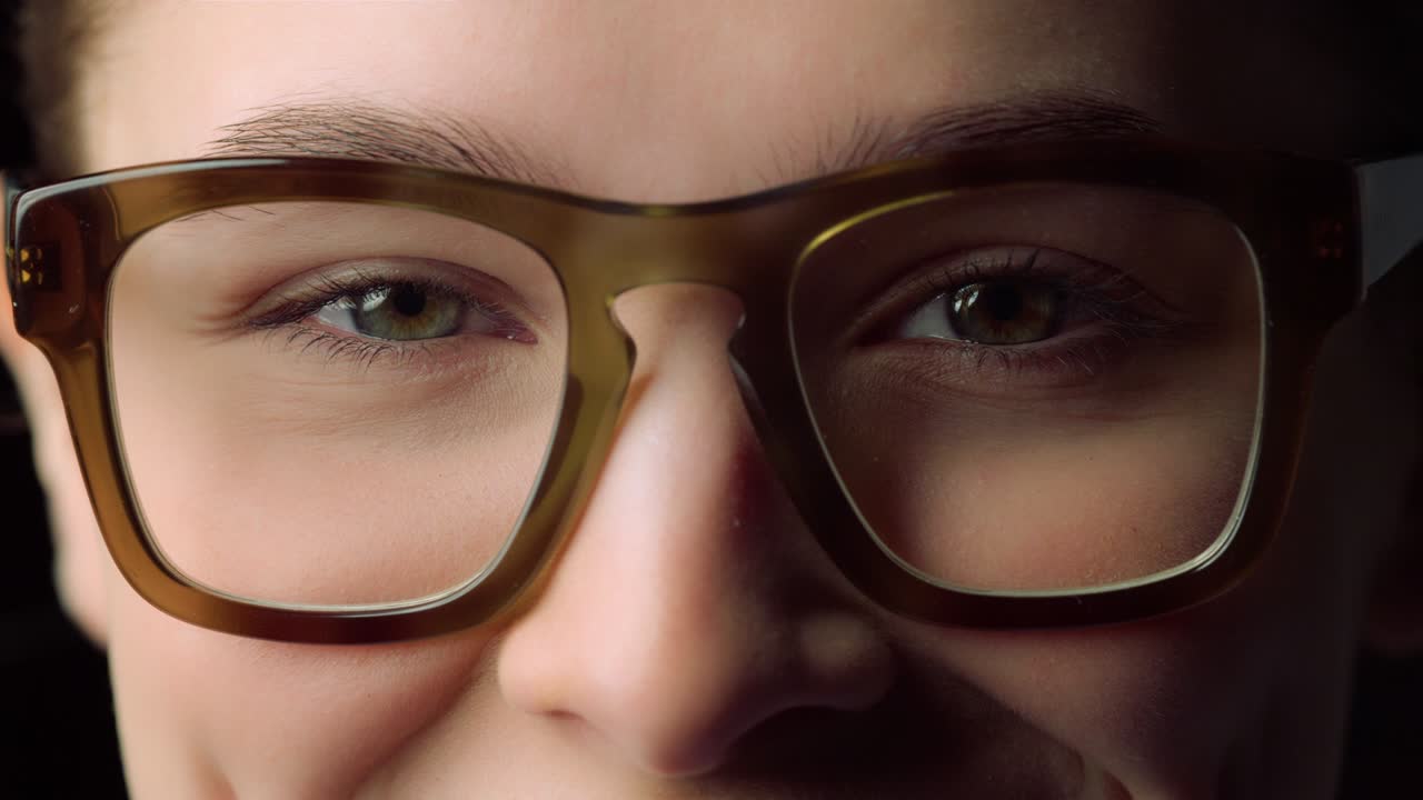 macro de una mujer joven sonriente que usa gafas en el interior. mujer de negocios.