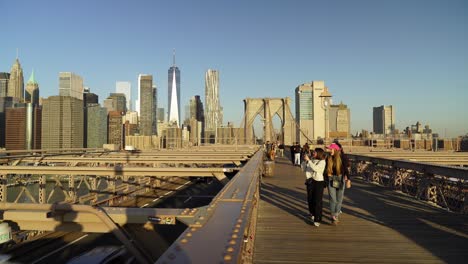walking the brooklyn bridge with manhattan skyline in the background
