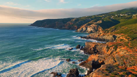 turquoise ocean greenery hills landscape aerial. waves rolling rocky coastline