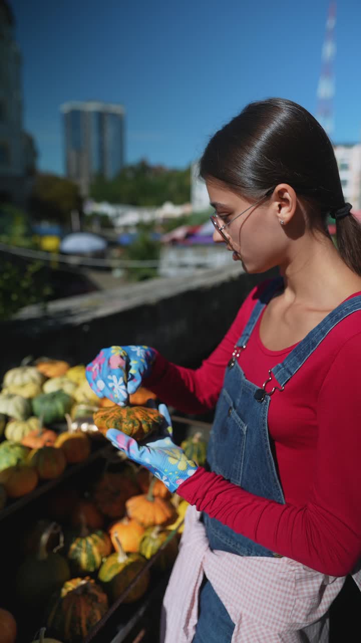 mujer comprando calabazas en un mercado de agricultores