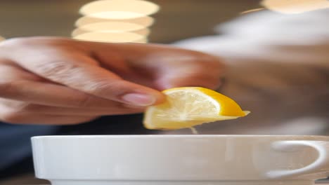 adding lemon to hot beverage