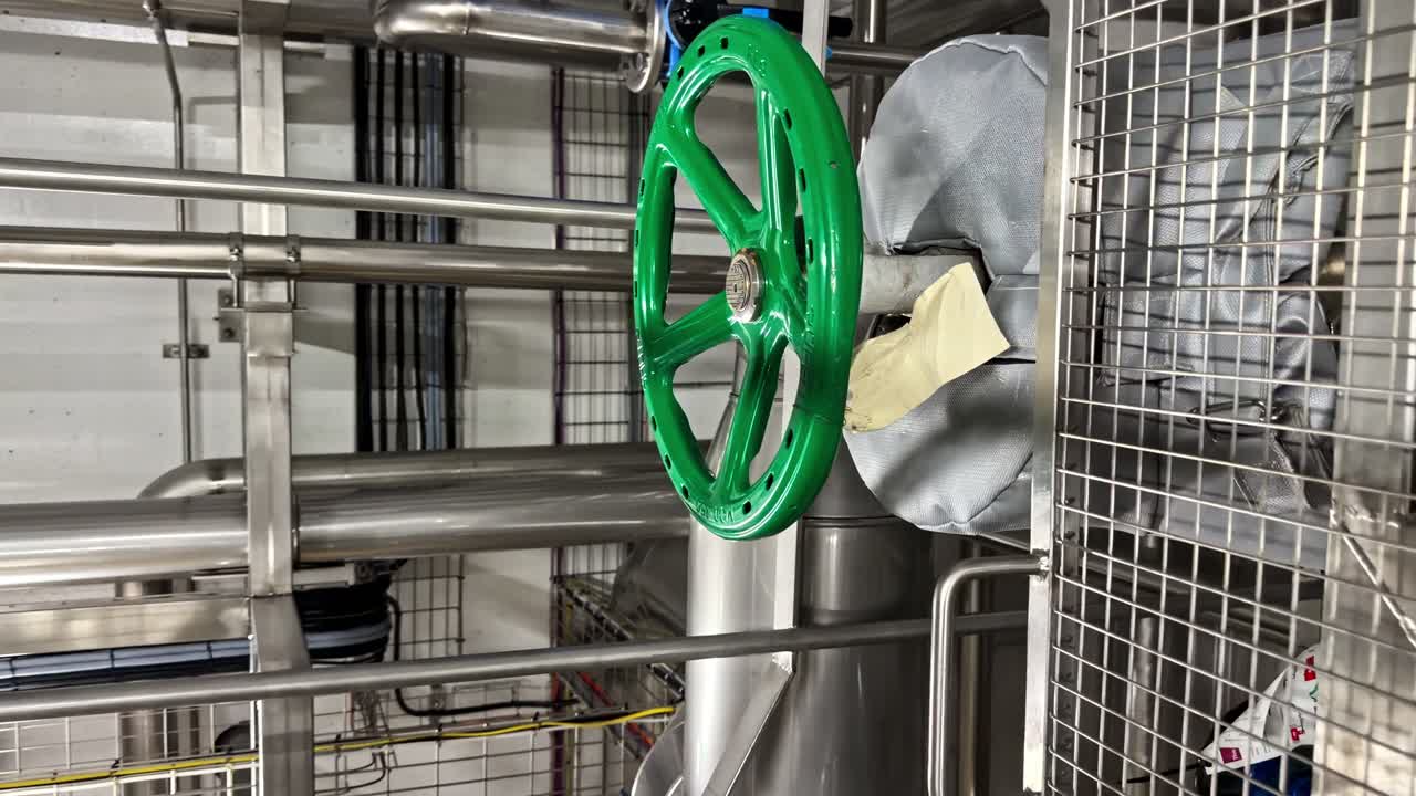 Close up of green industrial valve wheel in factory machinery details