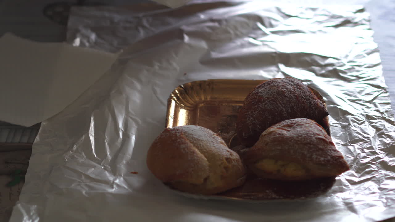 Close up hand of woman with age spots picking up a traditional famous italian neapolitan pastry called sfogliatella napoletana 4k