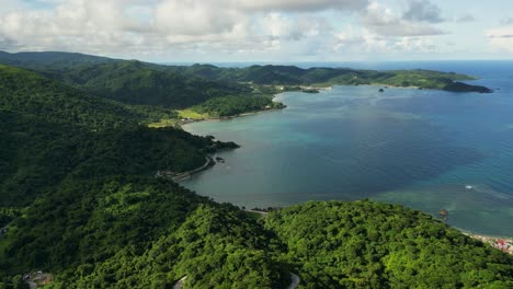 aerial drone shot of picturesque tropical island coast and lush mountains facing turquoise lagoon at baras, catanduanes, philippines