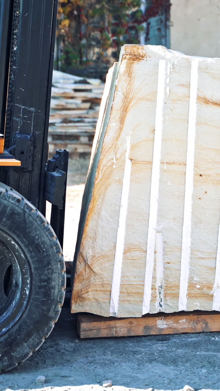 Man driving forklift. Driver loading marble block with equipment Vertical video