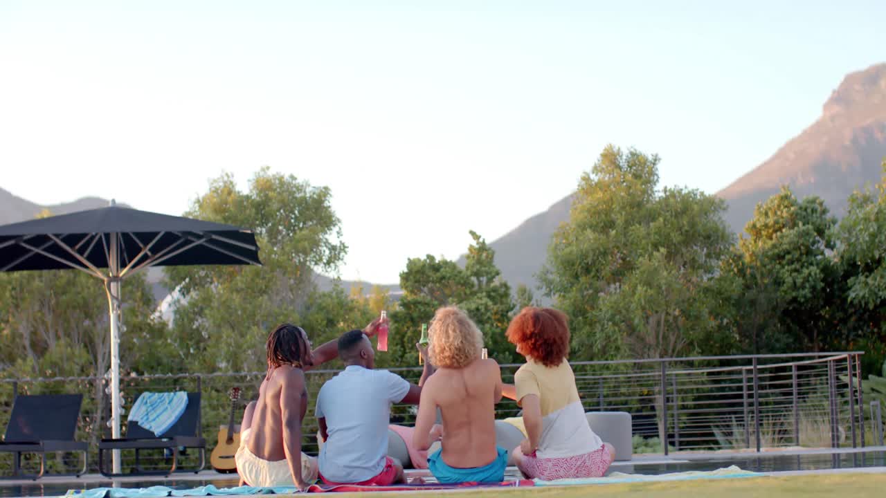 행복 한 다양한 친구 들 이 음료 를 마시며 슬로우 모션 으로 수영장 에서 환호 하고 있다