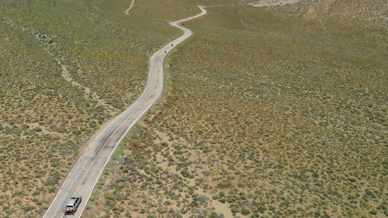 지저분한 언덕에 있는 오토바이와 자동차의 슬로우 모션 공중