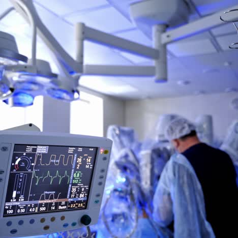 surgical room with medical monitors. heart rate monitor showing vital signs of a patient on the background of operating procedure in the hospital.