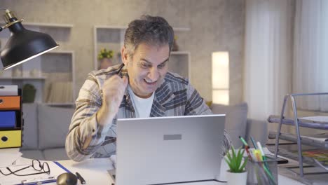 ganador hombre maduro emocionado mirando la computadora portátil y celebrando el éxito en línea.