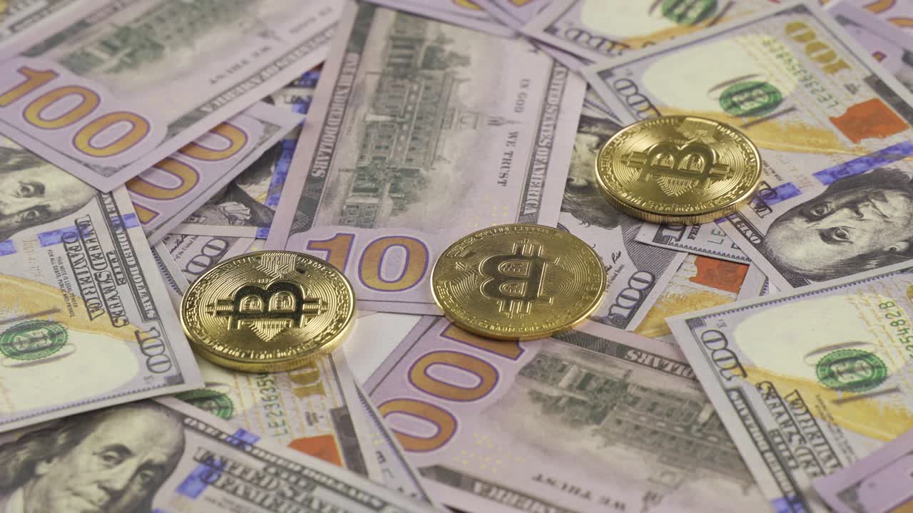 la moneda de oro bitcoin de cerca en el fondo de los billetes de cien dólares.