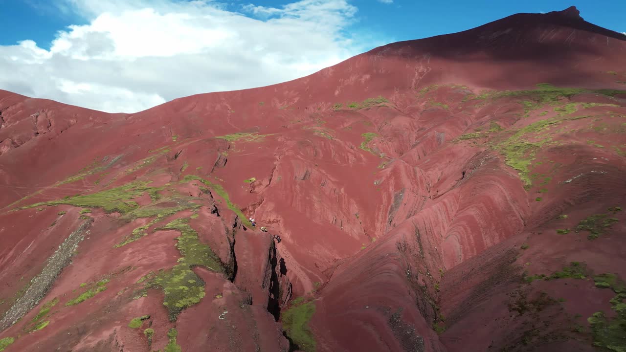 Aerial footage of hikers in Peru’s Red Valley. Towering peaks, deep valleys, and colorful land formations from above