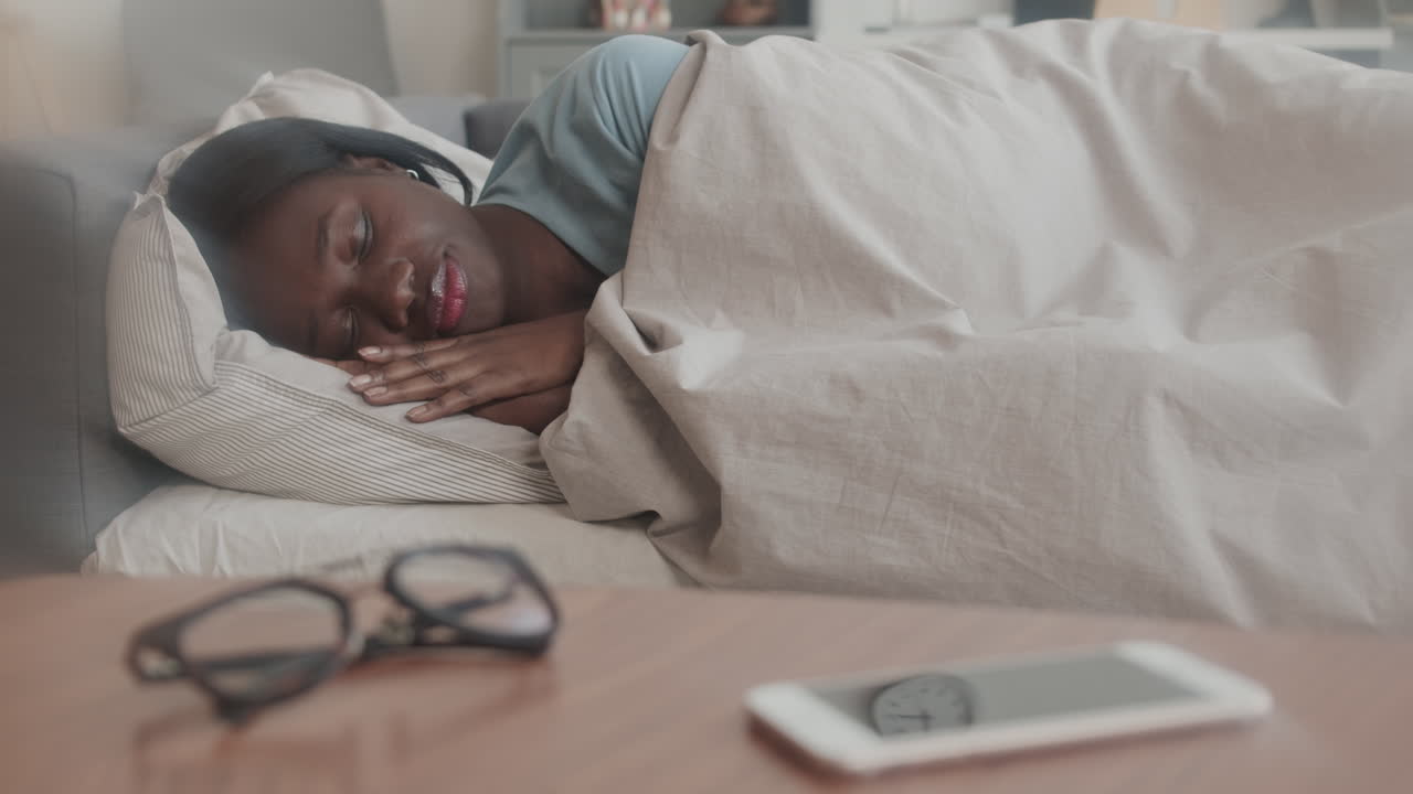Afrikansk kvinde sover i seng
