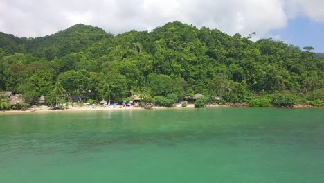 Toma-Aérea-Giratoria-De-Una-Pequeña-Playa-Tropical-Con-Ambiente-Hippy-En-Koh-Chang-Con-Vistas-A-La-Jungla-Y-Al-Mar