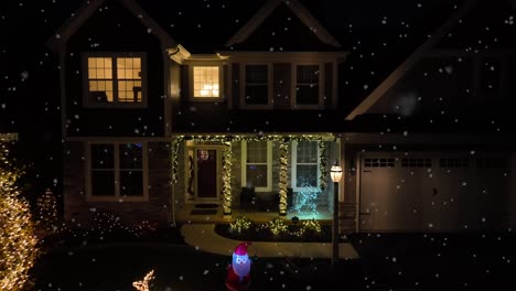 snow flurries over american home decorated for christmas with lights, reindeer, and santa blow up