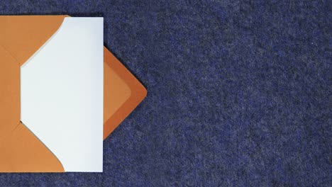el sobre de carta naranja que contiene un papel blanco entra y sale de la escena desde la izquierda de la pantalla