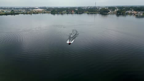 Water-skier-gets-pulled-out-of-the-water-by-ski-boat-on-an-overcast-winter-day-in-Winter-Haven-Florida
