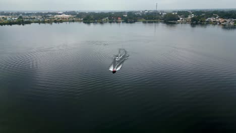 water skier gets pulled out of the water by ski boat on an overcast winter day in winter haven florida