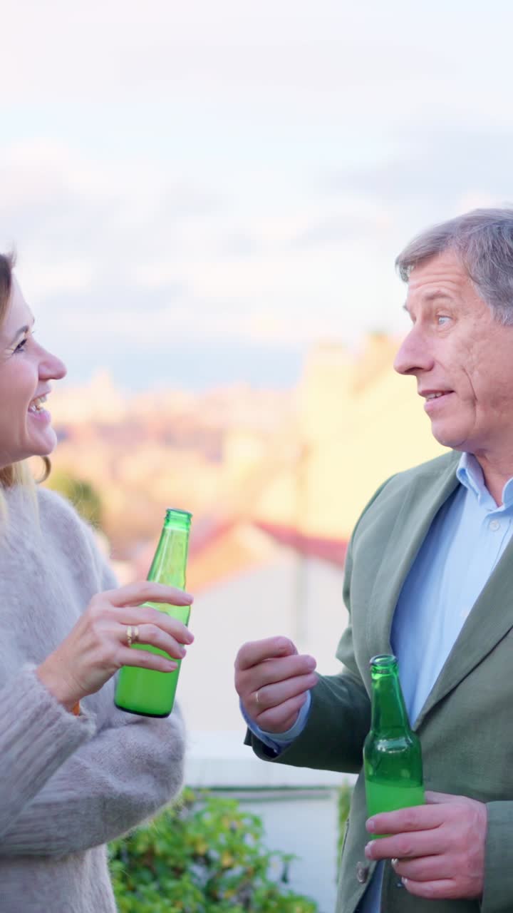 Uomo e donna che chiacchierano all'aperto con un drink