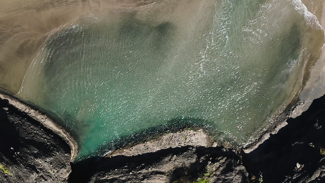 Piha Beach in Nuova Zelanda, costa selvaggia rocciosa e di sabbia nera, vista aerea dall'alto.
