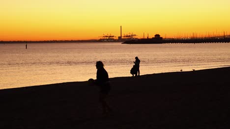 two people playing football during sunset