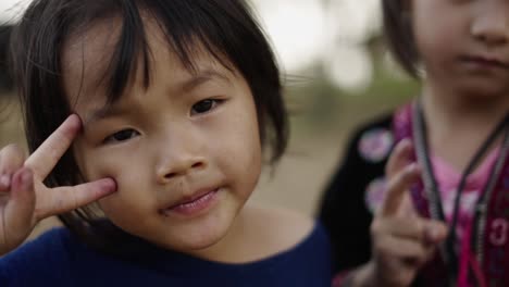 close-up portraits of young asian girls, one making a peace sign