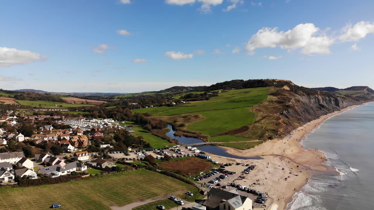 Aerial rising shot with a view looking over Charmouth towards the Cliffs and Beach in Dorset England UK
