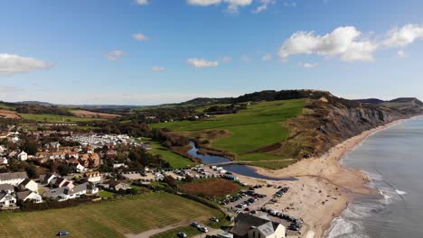 Disparo-Ascendente-Aéreo-Con-Vistas-A-Charmouth-Hacia-Los-Acantilados-Y-La-Playa-En-Dorset,-Inglaterra