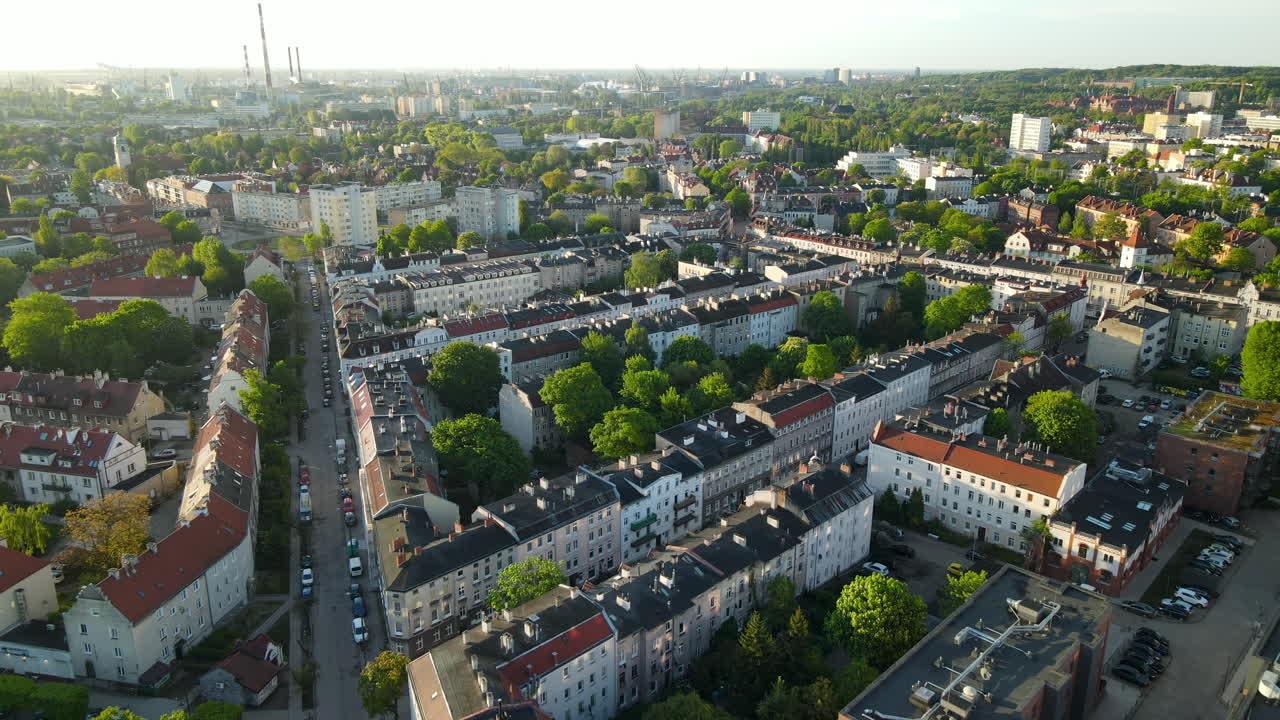 높은 관점에서 건물 일몰 근처에 주차된 차가 있는 그단스크 도시 옥상과 깨끗한 거리 위로 공중 비행, 복사 공간