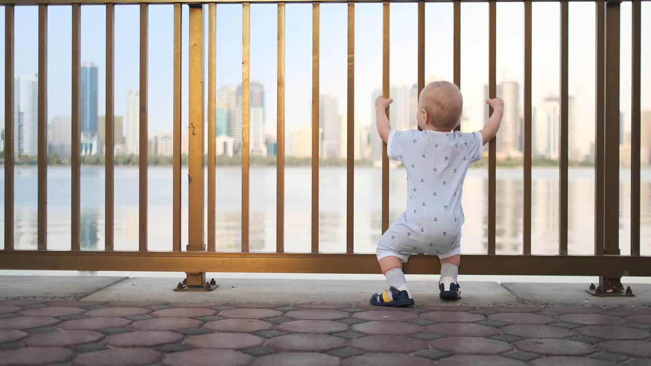 смеющийся мальчик в возрасте 1 года танцует.