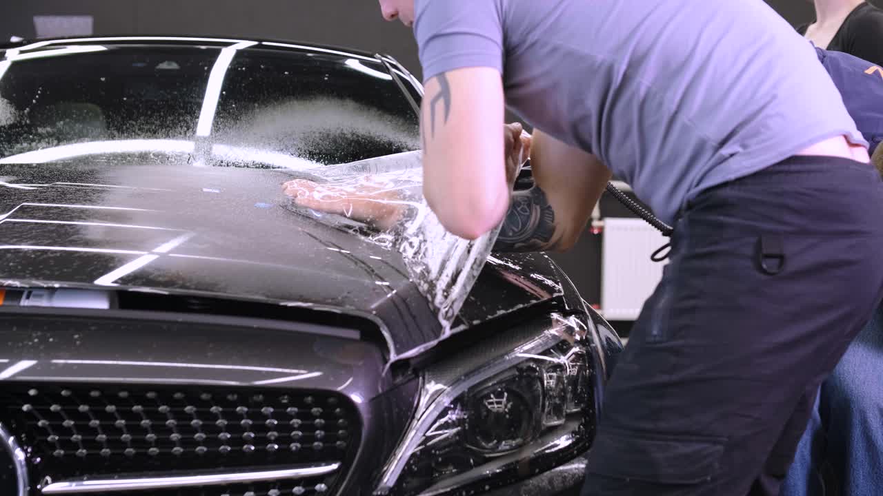 비닐 폴리우레탄 테이프로 자동차를 는 사람. 자동차를위한 필름. 자동차에 스티커 보호 필름