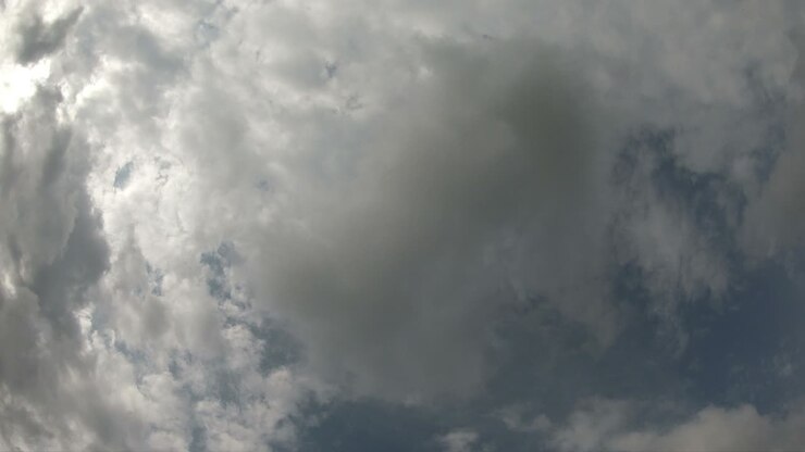 Time lapse of cloudscape with bright sun shining and revealing itself behind clouds.