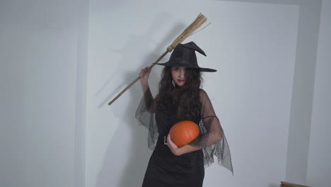 witch costume with broom and pumpkin